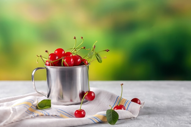 Cerejas frescas em uma caneca de ferro ao ar livre