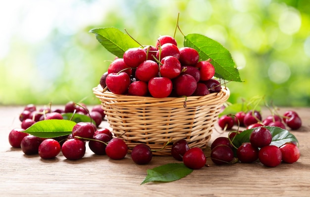 Cerejas frescas em uma cesta sobre uma mesa de madeira