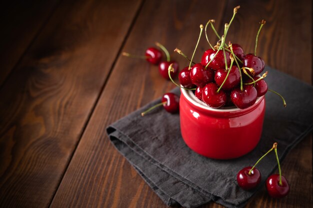 Cerejas frescas em uma tigela na mesa de madeira