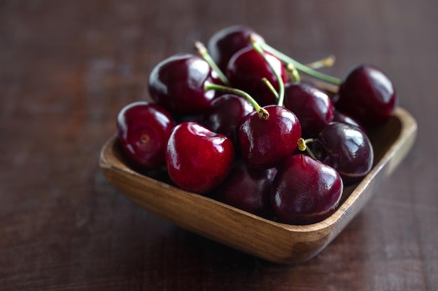 Cerejas frescas maduras em uma tigela de madeira