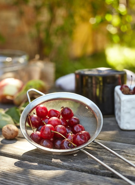 Cerejas lavadas frescas em uma peneira. Composição na mesa