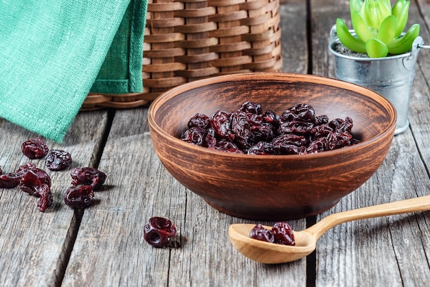 Cerejas secas em um prato de barro em uma mesa de madeira em estilo rústico