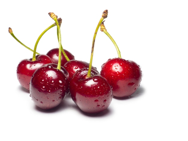 Cerejas suculentas em gotas de água sobre um fundo branco Comida útil Isolado de bagas bonitas Bagas maduras em cima da mesa Ingrediente para um prato