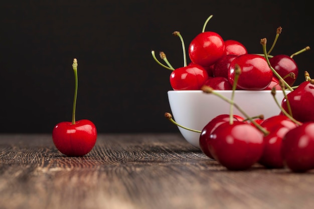 Cerejas vermelhas maduras em uma mesa de madeira