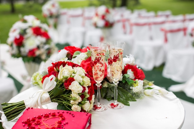 Ceremonia de boda al aire libre con sillas blancas y cintas rojas