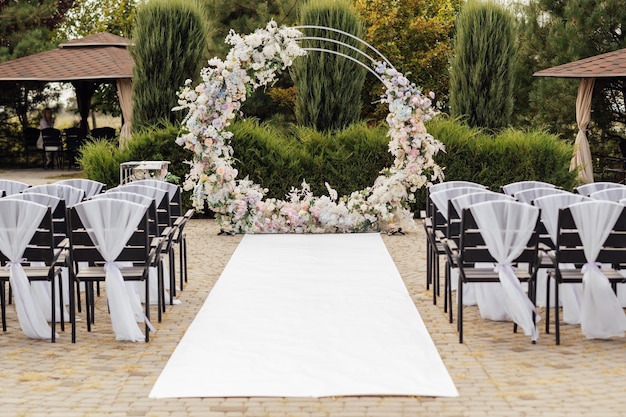 Ceremonia de boda Arco de boda muy hermoso y elegante decorado con varias flores frescas en el jardín