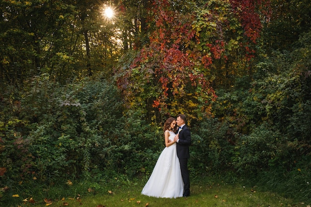 Ceremonia de boda con estilo creativo elegante joven novia y el novio al aire libre en el parque de otoño