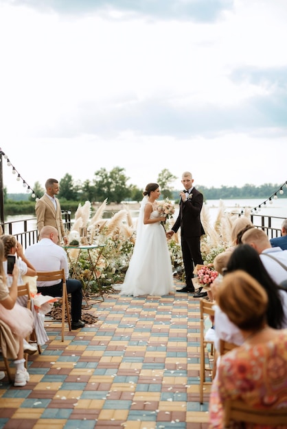 Ceremonia de boda en un muelle alto cerca del río.