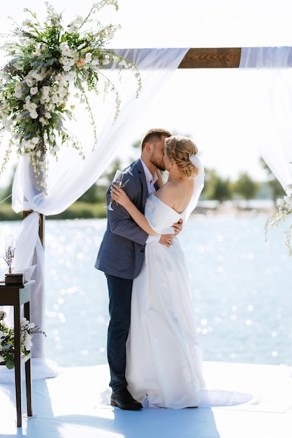 Ceremonia de boda en un muelle alto cerca del río.