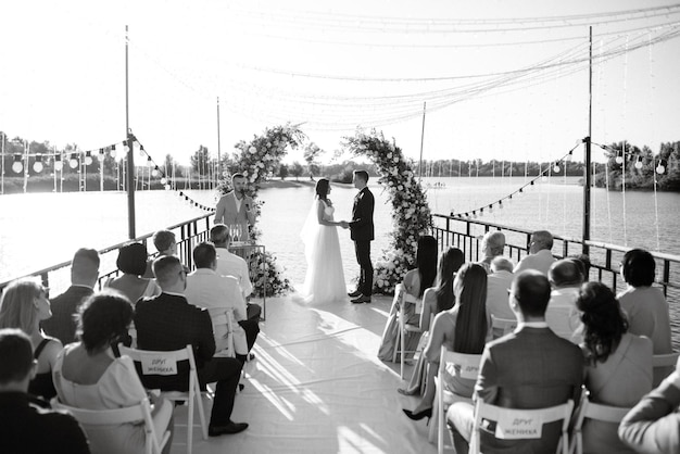 Ceremonia de boda en un muelle alto cerca del río.