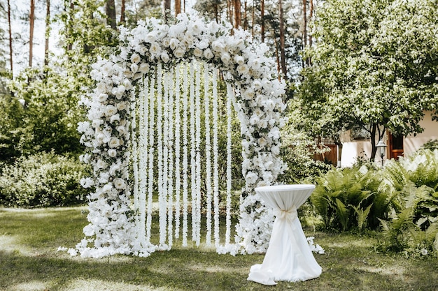 Ceremonia de boda en la naturaleza con un arco decorado con flores blancas  | Foto Premium
