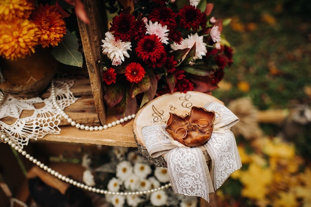 Ceremonia de boda de otoño en la calle sobre el césped verde. Decoración con arcos de flores frescas para la ceremonia.