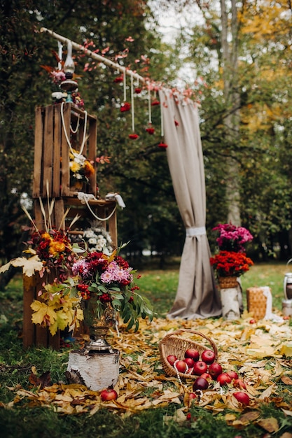 Ceremonia de boda de otoño en la calle sobre el césped verde. Decoración con arcos de flores frescas para la ceremonia.