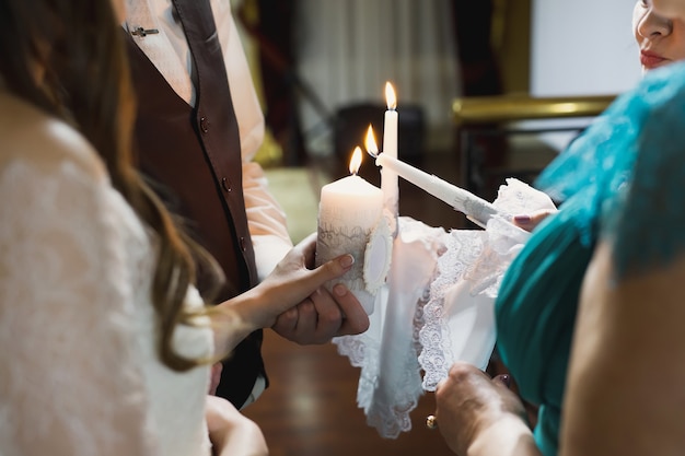Ceremonia de boda, parafernalia, la novia y el novio sostienen una vela grande en la mano