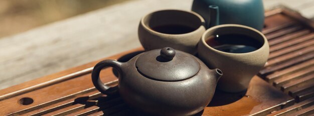 Ceremonia del té chino. Tetera de cerámica hecha de arcilla y cuencos sobre un fondo de madera.