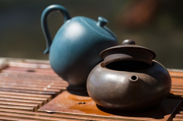 Ceremonia del té chino. Tetera de cerámica hecha de arcilla y cuencos sobre un fondo de madera.