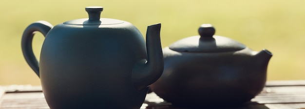 Ceremonia del té chino. Tetera de cerámica hecha de arcilla y cuencos sobre un fondo de madera.