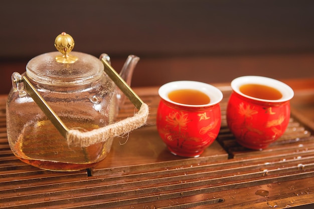 Ceremonia del té chino Tetera de cerámica hecha de arcilla y tazones sobre un fondo de madera