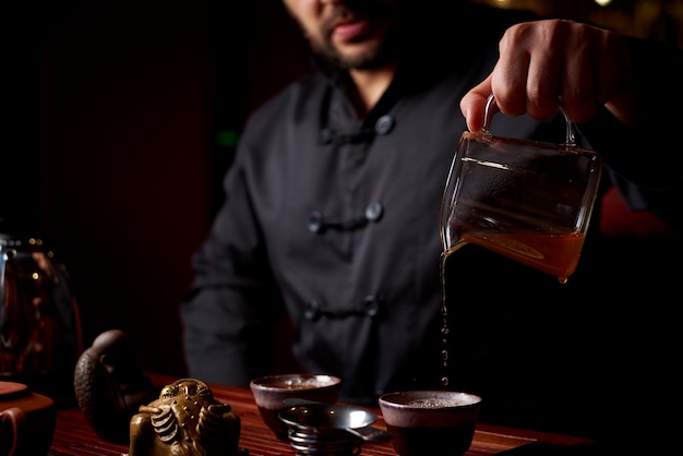 Ceremonia del té. Un joven vierte té de una tetera.