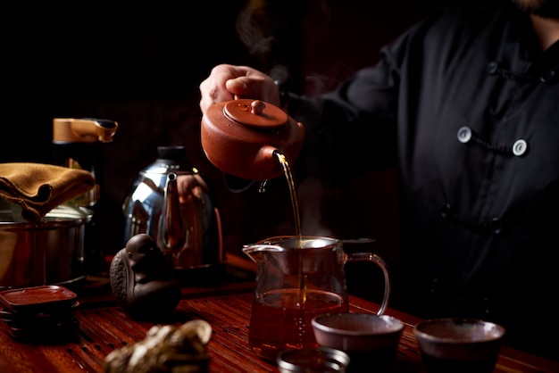 Ceremonia del té. Un joven vierte té de una tetera.