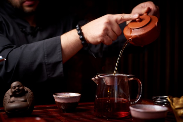 Ceremonia del té. Un joven vierte té de una tetera.