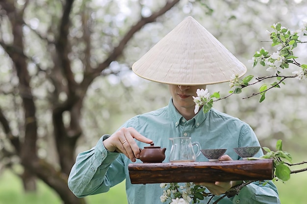 ceremonia del té, el maestro del té asiático prepara té verde fresco de primavera en el jardín