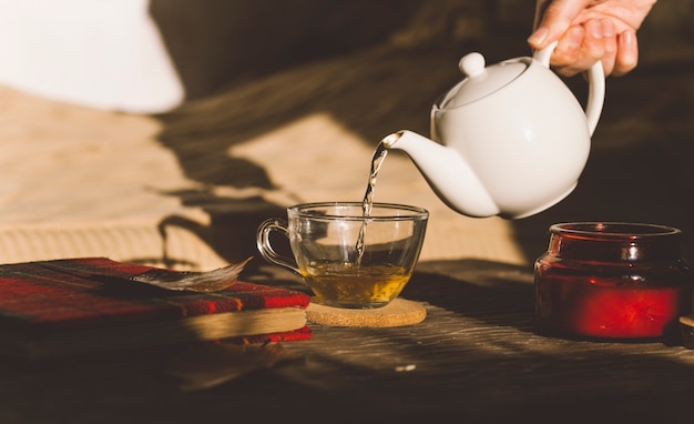 Ceremonia del té con una taza de café y una tetera en una mesa de madera