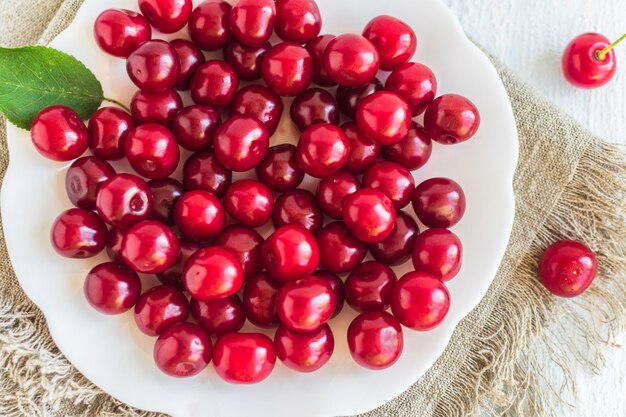 Cereza dulce en un plato de cerca sobre un fondo blanco Vista superior