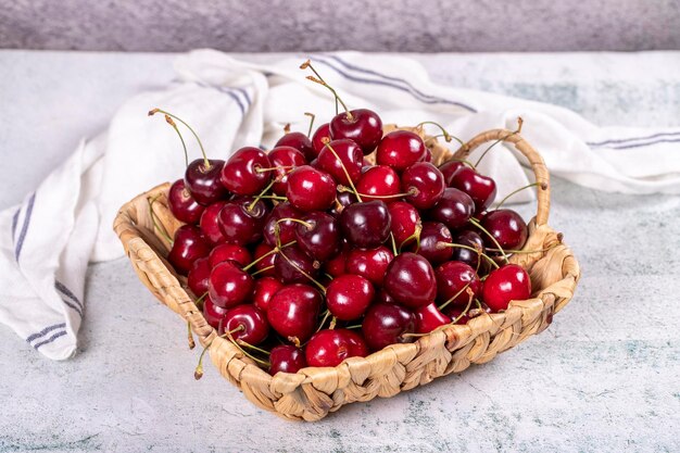 Cereza fresca Cerezas maduras en una cesta sobre un fondo de piedra Cerezas a granel de cerca