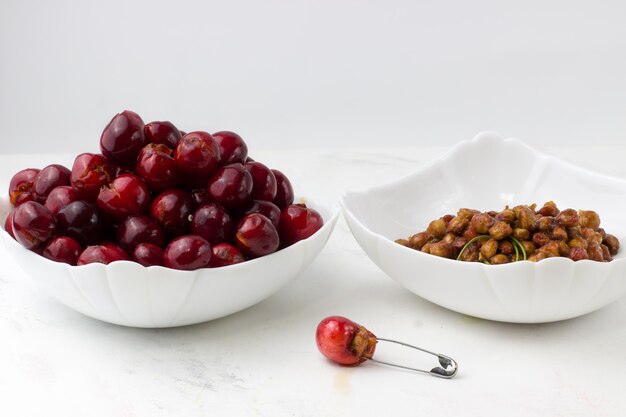 Cereza sin hueso sobre un fondo blanco. El proceso de quitar los huesos de las cerezas.