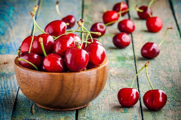 Cereza jugosa madura en un recipiente sobre una mesa de madera rústica