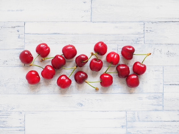 Cereza roja sobre fondo blanco de madera