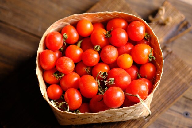 cereza de tomate en la cesta de bambú tejida. Solanum lycopersicum var. cerasiforme. tomate redondo pequeño.