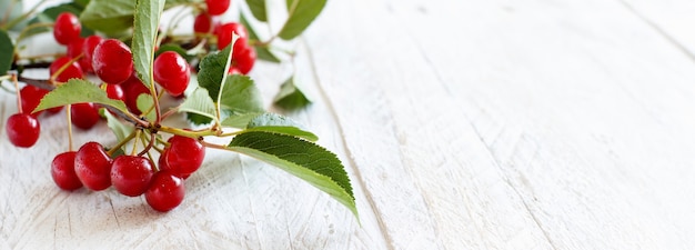 Cerezas agrias frescas en una mesa de madera blanca