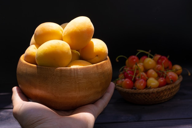 Cerezas y albaricoques en madera