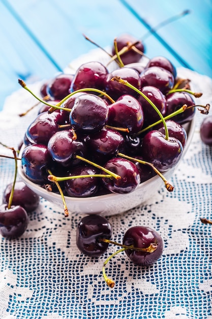 Cerezas. Cerezas. Cerezas dulces frescas. Cerezas deliciosas con gotas de agua en un recipiente sobre la mesa.