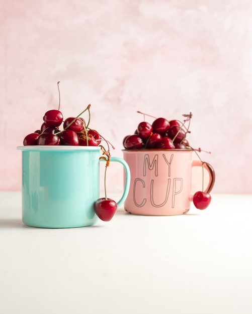 Foto cerezas dulces frescas en tazas de té