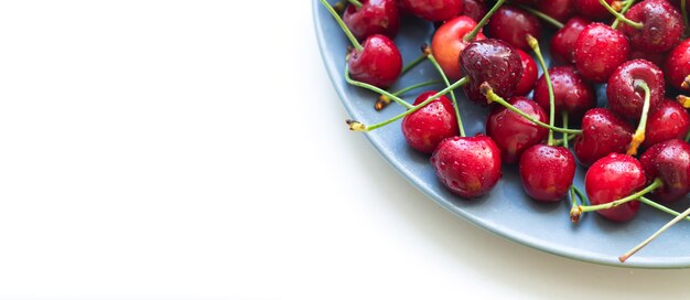 Foto cerezas dulces orgánicos húmedos rojos en placa gris aislado