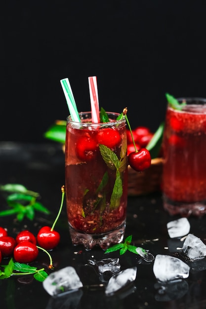 Cerezas frescas colocadas en una cesta y cerezas negras con salpicaduras de agua.