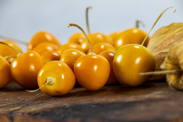 Cerezas frescas de invierno Physalis uvilla aguaymanto uvilla fruta peruana en una madera