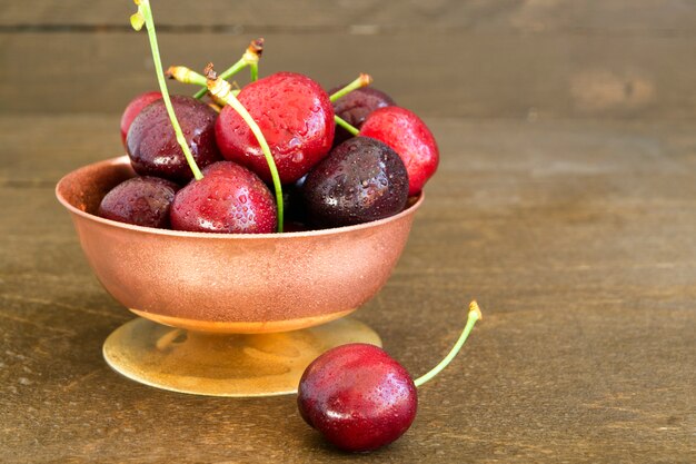 Cerezas frescas maduras sobre fondo de madera.