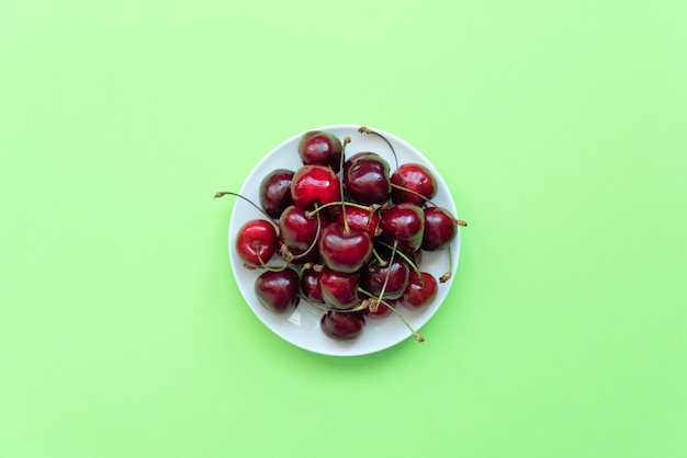 Cerezas frescas en plato blanco. Alimentación saludable, conceptos de minimalismo. Estilo plano