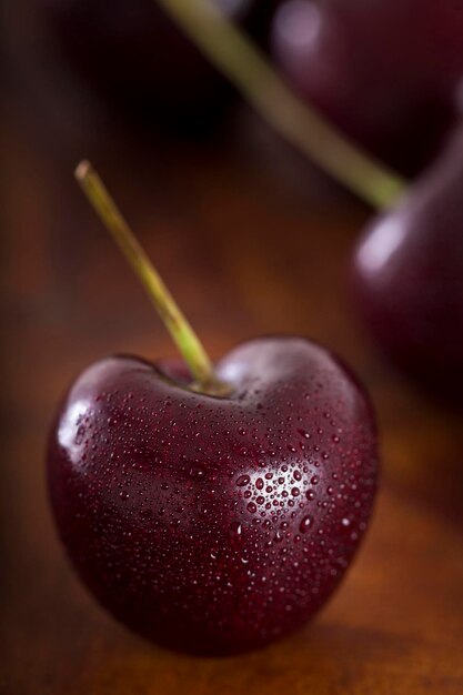 Cerezas frescas sobre fondo de madera oscura.