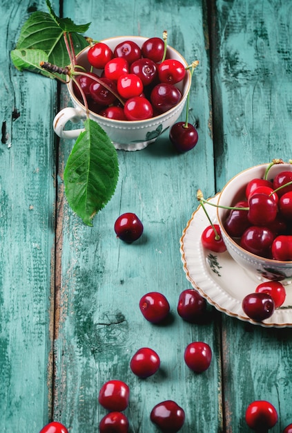 Cerezas frescas en una taza de té vintage