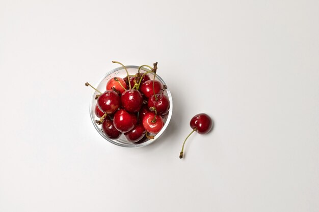 Cerezas frescas en un tazón de vasos, vista superior de la cosecha de ciruela