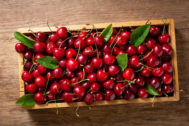 Cerezas frescas en una vista superior de caja de madera