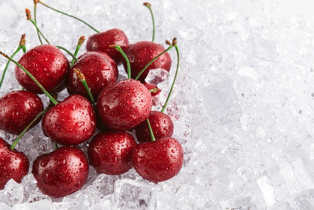 Cerezas en hielo sobre un fondo blanco.