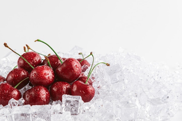 Cerezas en hielo sobre un fondo blanco.