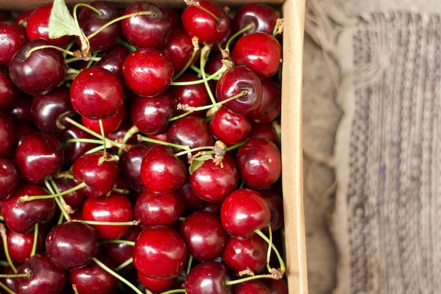 Foto cerezas maduras dentro de una caja de cartón frutas de temporada