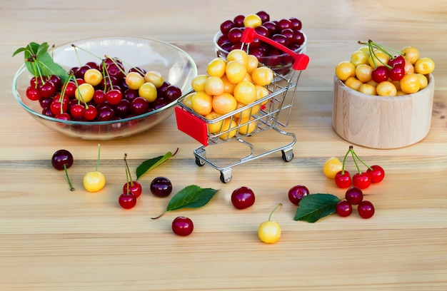 Cerezas maduras frescas en carro de compras, concepto de comprar frutas y bayas.